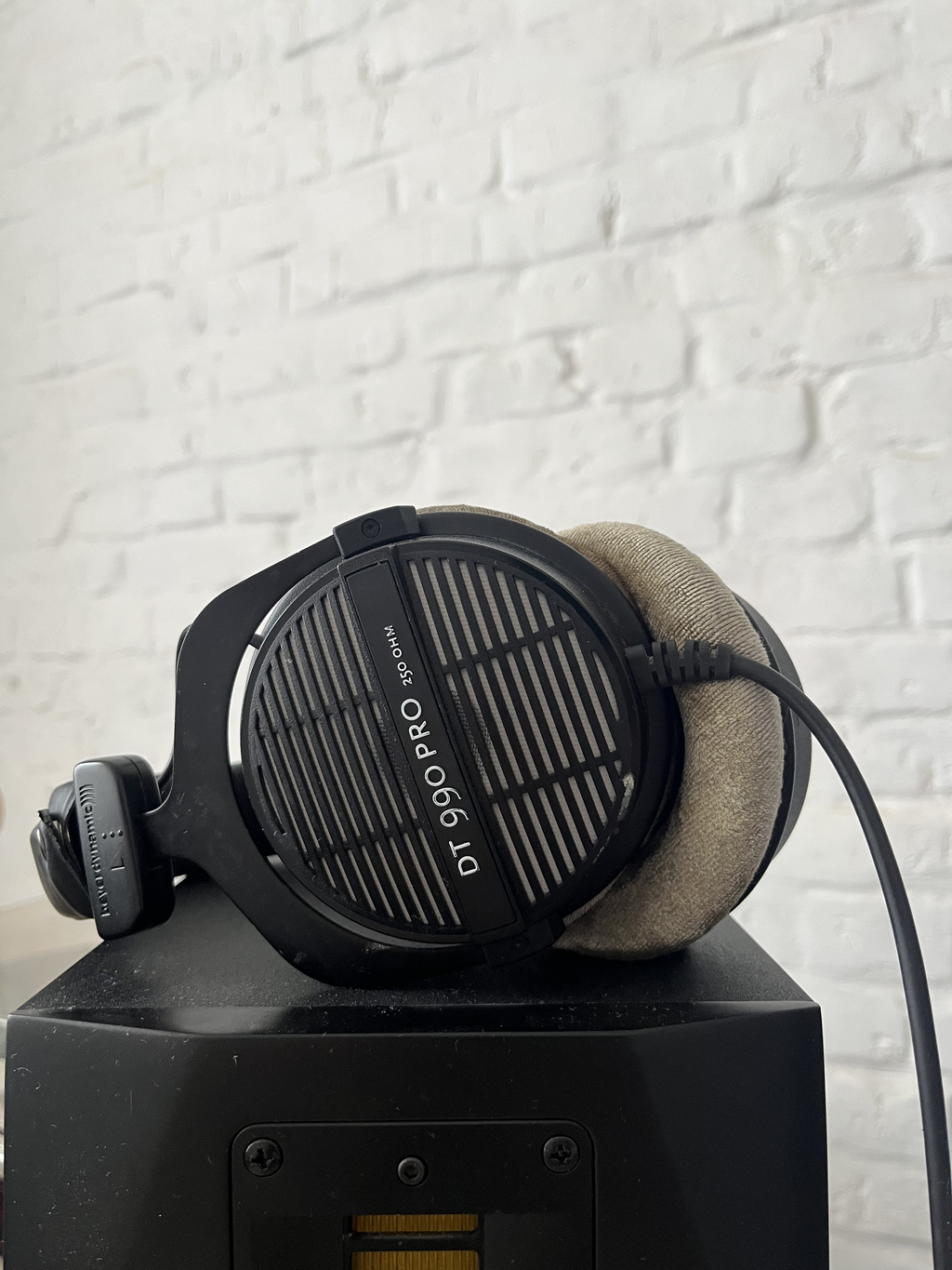 Beyerdynamic DT 990 Pro 250 Ohm beside a studio monitor in a home studio