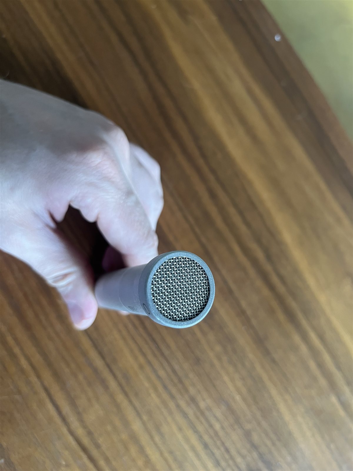 Oktava MK-012 small-diaphragm condenser microphone held in a hand.