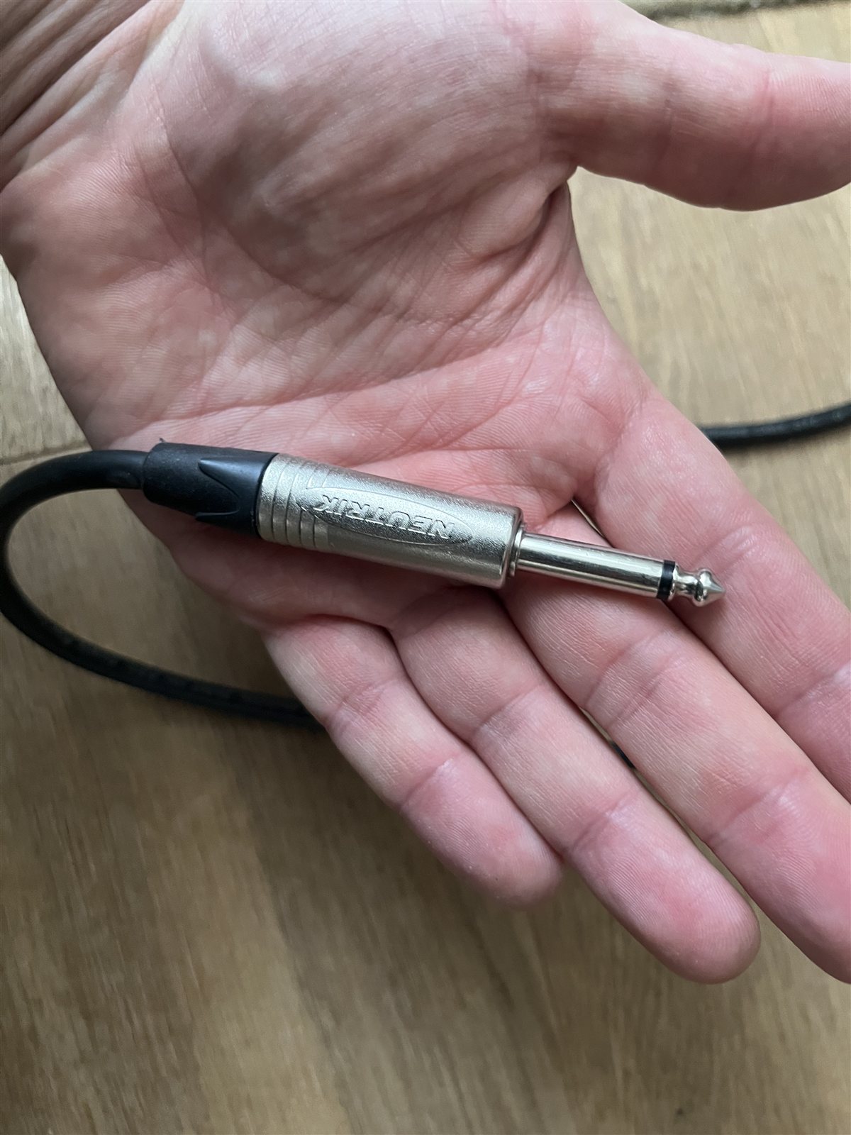 Quarter-inch audio adapter held in a hand.