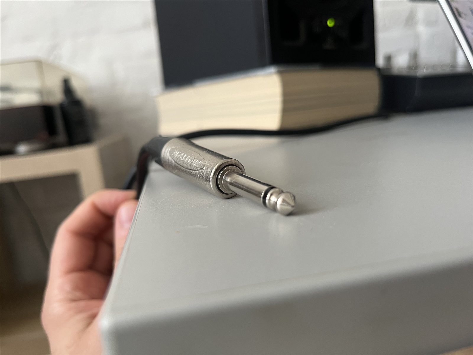 Quarter-inch audio cable plug in a desktop studio workspace.